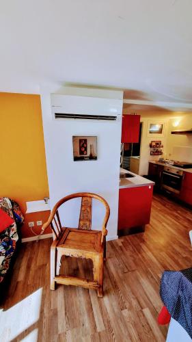 une chaise en bois dans une pièce avec une cuisine dans l'établissement Grand T2 Ensoleillé 47m2 3 Etoiles, à La Grande Motte