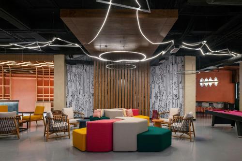 a room with colorful chairs and a pool table at Aloft Cancun in Cancún