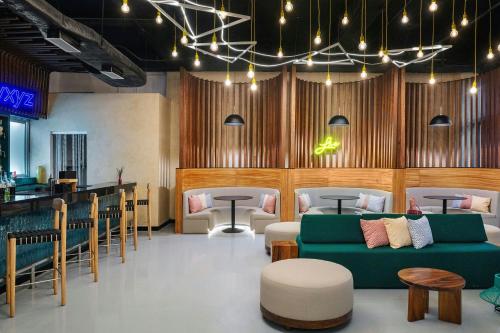 a restaurant with couches and tables and a bar at Aloft Cancun in Cancún