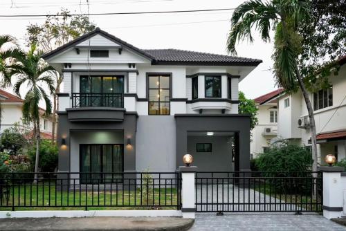 a house with a black fence in front of it at บ้านชลดา in Ban Wang Pong