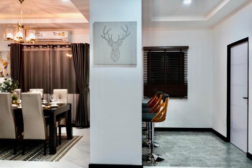 a dining room with a table with chairs and a picture on the wall at บ้านชลดา in Ban Wang Pong