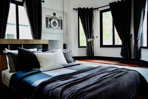 a bedroom with a large bed with windows and a radio at บ้านชลดา in Ban Wang Pong