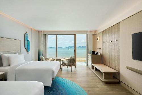 a hotel room with a bed and a view of the ocean at Veranda Resort Phuket, Autograph Collection in Panwa Beach