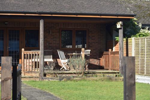 a porch of a house with chairs and a table at Spacious Garden Studio in Kings Langley
