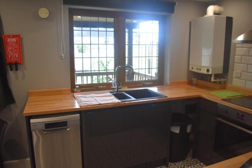 a kitchen with a sink and a counter with a window at Spacious Garden Studio in Kings Langley