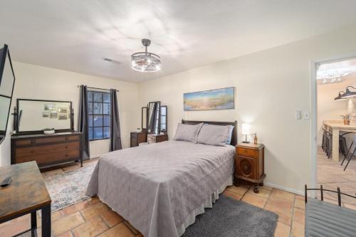 a bedroom with a bed and a dresser and a table at Historic Carriage House Downtown 2 bedroom 1 bath in Ocala