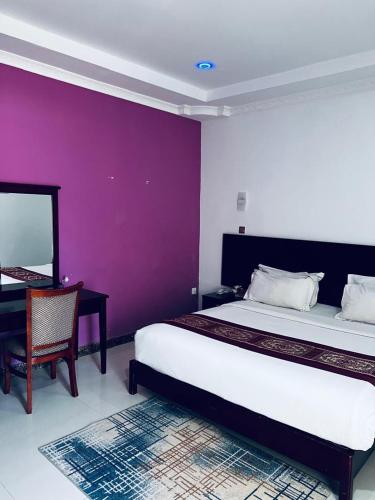 a bedroom with a large bed and a purple wall at Mthuzi Nadi Lodge in Chirundu