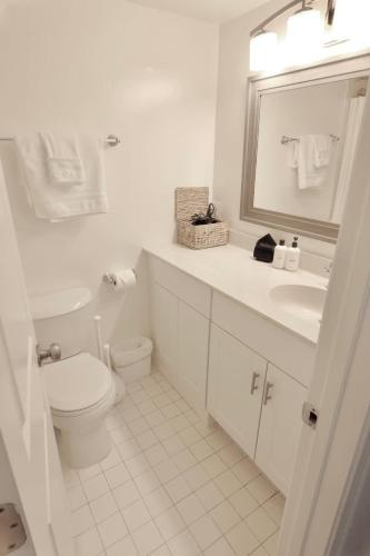 a white bathroom with a toilet and a sink at Capitol Hill & Penn - Steps from Eastern Market in Washington, D.C.