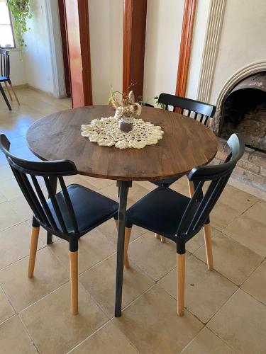 a wooden table with two chairs and a dining room at Sayani Posada in Chilecito