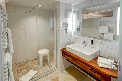 a white bathroom with a sink and a shower at Landgasthof Zur Post in Schwangau