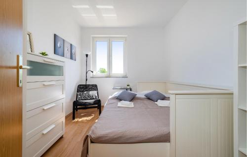 a small bedroom with a bed and a chair at 3 Bedroom Cozy Home In Brisevo in Briševo