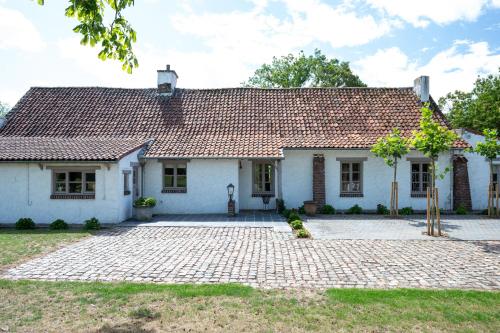 a white house with a tile roof at House on the Green in Waregem