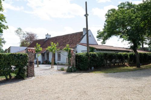 an exterior view of a white house with a fence at House on the Green in Waregem