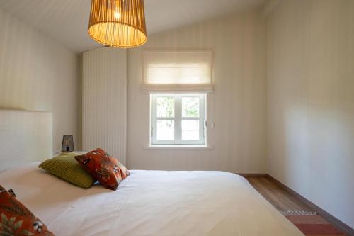 a bedroom with a large white bed with a window at House on the Green in Waregem