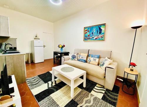 a living room with a couch and a table at Maison proche plage et centre ville avec ménage, draps et serviettes inclus in Arcachon
