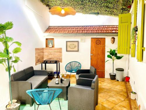 a living room with a couch and chairs and a table at Maison proche plage et centre ville avec ménage, draps et serviettes inclus in Arcachon