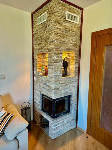 a stone fireplace in the corner of a living room at Pirin Golf View Apartment Bansko in Bansko