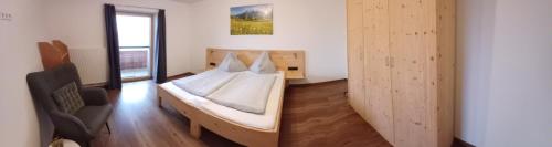 a bedroom with a bed and a chair in it at Ferienwohnung Kramerhof in Ebbs