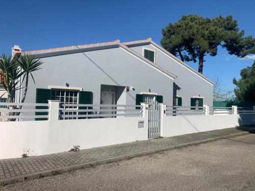 a white house with a white fence at The Sweet Dreams Holiday House in Azeitao