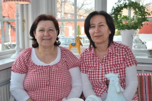 two women sitting next to each other at a table at Hem till Gården boutique hotel in Västerås