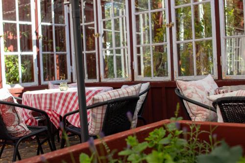 a patio with a table and chairs and windows at Hem till Gården boutique hotel in Västerås