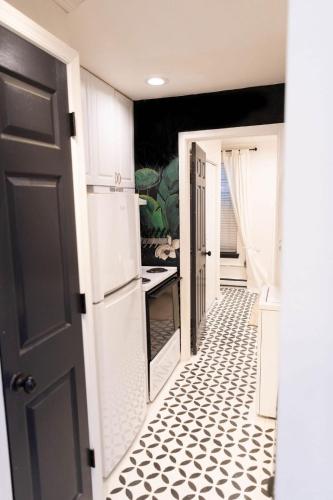a kitchen with a black door and a black and white tile floor at Charming and Historic Apartment in Capitol Hill in Washington, D.C.