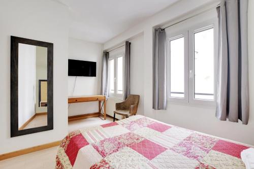 a bedroom with a bed and a mirror and a desk at Hotel de l'Europe in Paris
