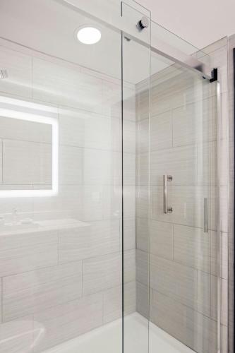 a shower with a glass door in a bathroom at Courtyard by Marriott Boston Brookline in Brookline