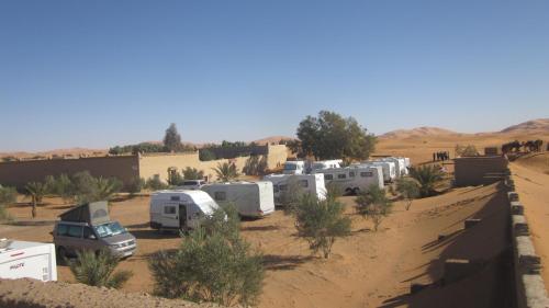 a group of rvs parked in the desert at Hôtel Camping La Liberté in Merzouga
