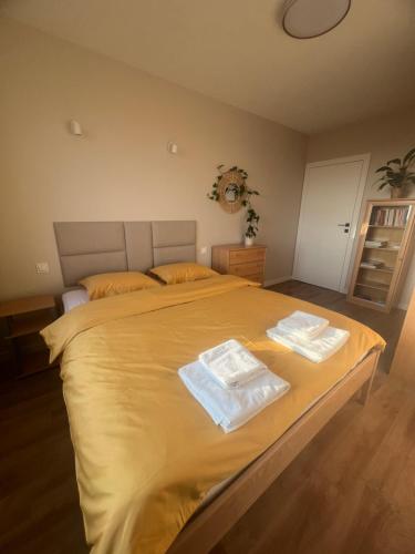 a bedroom with a large bed with two towels on it at Apartament Broniewskiego in Busko-Zdrój