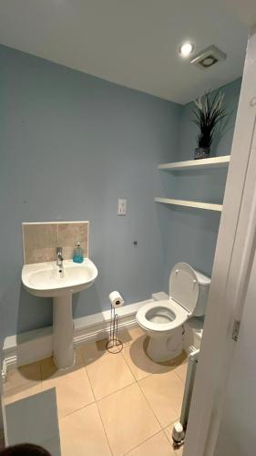 a bathroom with a white toilet and a sink at Ensuite Private Cosy Space Near the Bus Station in Broughton