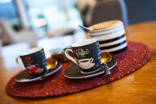 two coffee cups sitting on a table with spoons at Chata FONGRUB in Mýto pod Ďumbierom