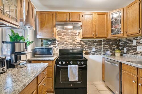 a kitchen with wooden cabinets and a black stove at USNA Home In Downtown Annapolis in Annapolis