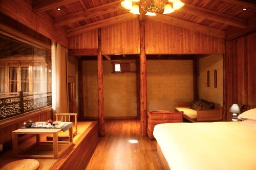 a bedroom with a bed and a table in a room at Standing in the wild in Xiwu