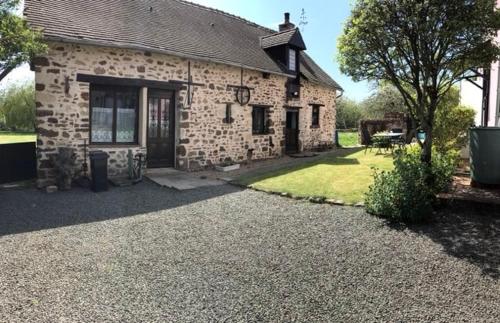 a stone house with a driveway in front of it at Les Hirondelles in Chemiré-en-Charnie
