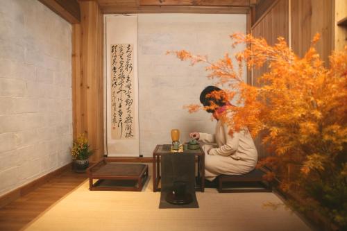 a woman sitting at a table in a room at Standing in the wild in Xiwu