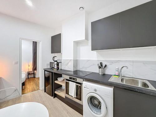 une cuisine avec une machine à laver et un évier dans l'établissement My Home Saint Jérome 2, à Lyon