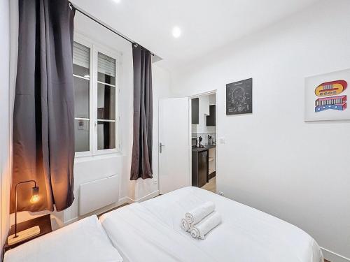een witte kamer met een bed en een raam bij My Home Saint Jérome 2 in Lyon