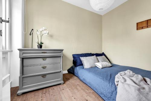 a bedroom with a blue bed and a dresser at Classic Super central - Balcony - 6 pers in Oslo
