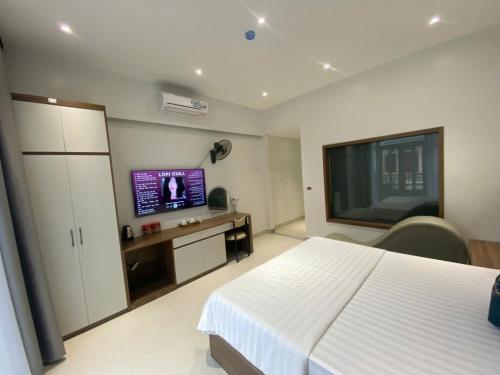 a bedroom with a bed and a flat screen tv at Nhà Nghỉ Moonlight in Hanoi