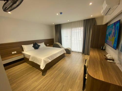 a hotel room with a bed and a television at Nhà Nghỉ Moonlight in Hanoi