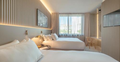 a hotel room with two beds and a window at Carlemany Girona in Girona