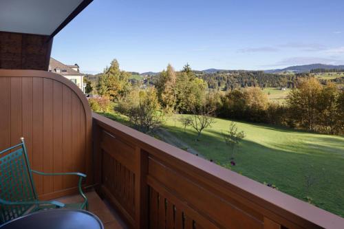 a balcony with a bench and a view of a field at Arabella Jagdhof Resort am Fuschlsee, a Tribute Portfolio Hotel in Hof bei Salzburg