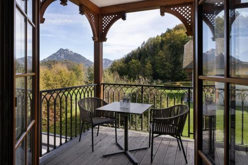 a table and chairs on a balcony with a view at Arabella Jagdhof Resort am Fuschlsee, a Tribute Portfolio Hotel in Hof bei Salzburg