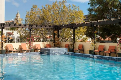 a swimming pool with chairs and a pergola at Courtyard Miami Coral Gables in Miami