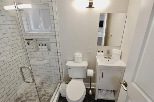 a white bathroom with a toilet and a sink at Darling Apartment in Capitol Hill - TWO min to Metro in Washington, D.C.