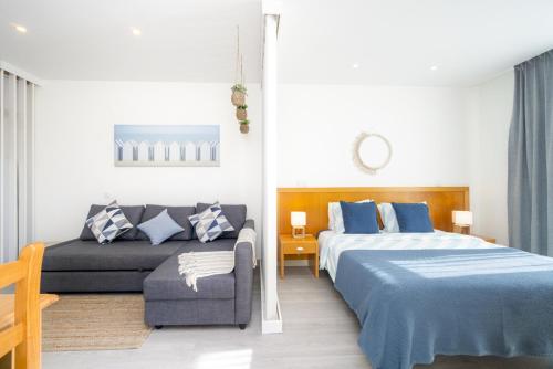 a bedroom with two beds and a couch at Bay View by OCvillas in Albufeira