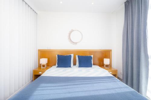 a bedroom with a blue bed with two blue pillows at Bay View by OCvillas in Albufeira
