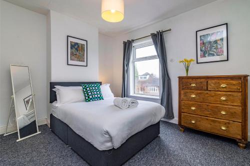 a bedroom with a bed and a dresser and a window at Beeston town house - Sleeps 4 in Beeston