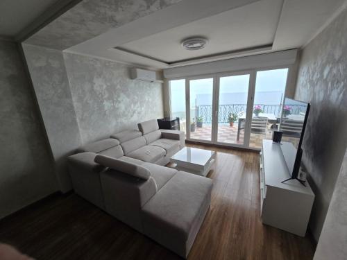 a living room with a couch and a television at Apartament with sea view in Nice